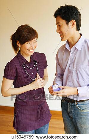 Stock Photo - Close-up of a young man offering a ring to a young woman. Fotosearch