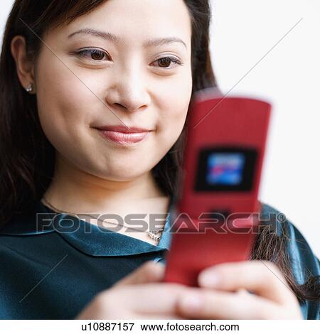 Stock Photo - Close-up of a young woman holding a mobile phone. Fotosearch