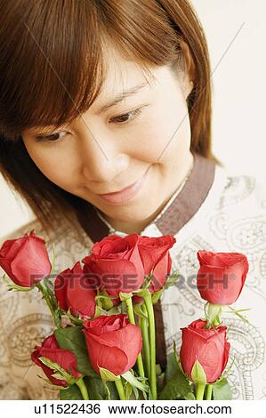 Close-up of a young woman holding a bouquet of red roses View Large Photo Image Stock Photograph - Close-up of a young woman holding a bouquet of red roses. Fotosearch