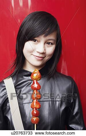 Close-up of a young woman holding avocado's on a stick View Large Photo Image Stock Image - Close-up of a young woman holding avocado's on a stick. Fotosearch