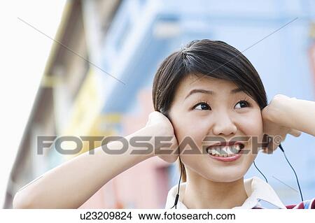 Close-up of a young woman listening to music View Large Photo Image Picture - Close-up of a young woman listening to music. Fotosearch