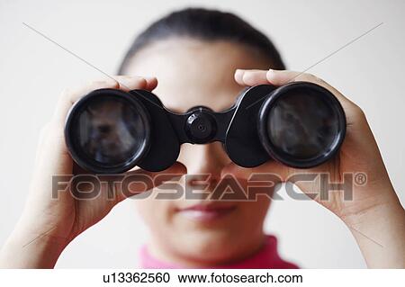 Close-up of a young woman looking through a pair of binoculars View Large Photo Image Stock Image - Close-up of a young woman looking through a pair of binoculars. Fotosearch