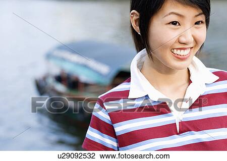 Close-up of a young woman smiling View Large Photo Image Stock Image - Close-up of a young woman smiling. Fotosearch