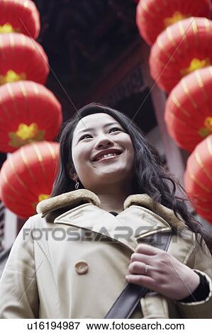 Close-up of a young woman standing in front of hanging Chinese lanterns View Large Photo Image Stock Photo - Close-up of a young woman standing in front of hanging Chinese lanterns. Fotosearch