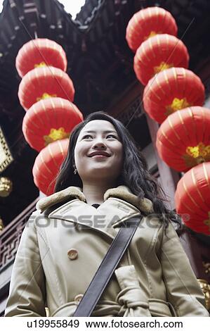 Close-up of a young woman standing in front of hanging Chinese lanterns View Large Photo Image Stock Photo - Close-up of a young woman standing in front of hanging Chinese lanterns. Fotosearch