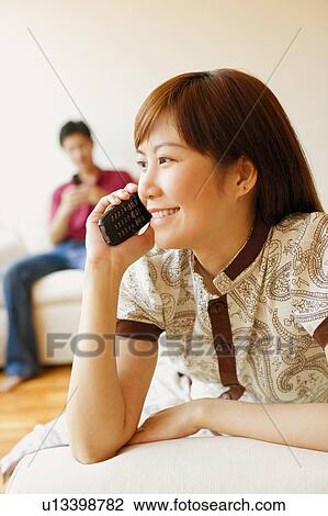 Close-up of a young woman talking on a mobile phone and smiling View Large Photo Image Stock Image - Close-up of a young woman talking on a mobile phone and smiling. Fotosearch