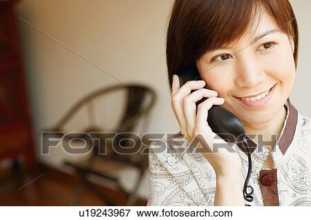 Close-up of a young woman talking on the telephone View Large Photo Image Stock Photo - Close-up of a young woman talking on the telephone. Fotosearch