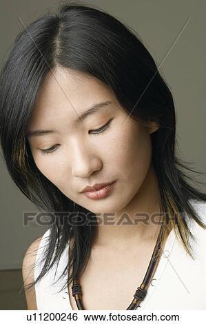 Stock Photograph - Close-up of a young woman thinking. Fotosearch