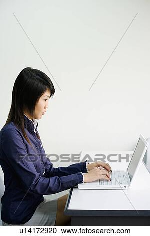 Close-up of a young woman using a laptop View Large Photo Image Stock Image - Close-up of a young woman using a laptop. Fotosearch