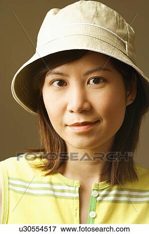 Close-up of a young woman wearing a hat View Large Photo Image Stock Photo - Close-up of a young woman wearing a hat. Fotosearch