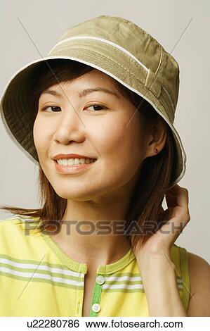 Stock Photograph - Close-up of a young woman wearing a hat. Fotosearch
