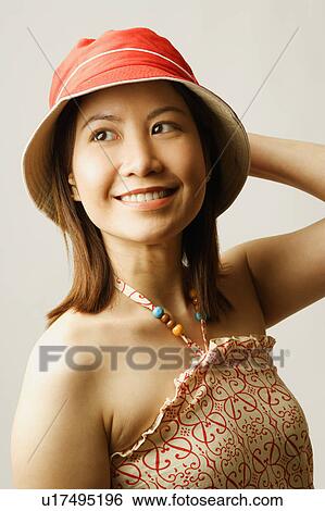 Close-up of a young woman with her hand on her head View Large Photo Image Stock Photograph - Close-up of a young woman with her hand on her head. Fotosearch