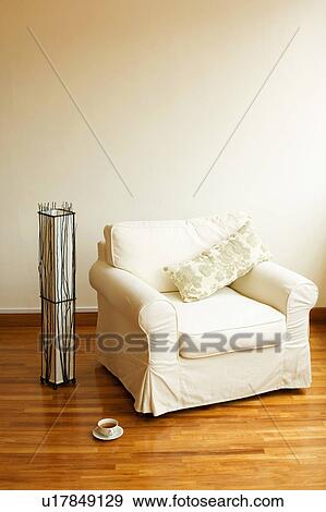 Stock Photo - Close-up of an armchair on a wooden floor. Fotosearch