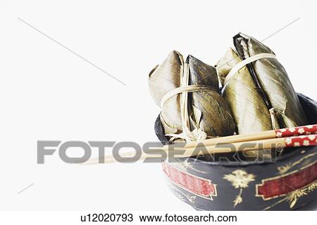 Stock Image - Close-up of food in a bowl with a pair of chopsticks. Fotosearch