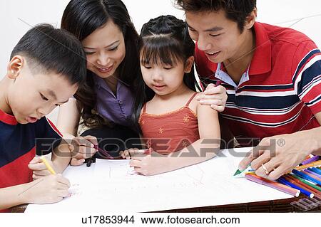 Picture - Close-up of parents drawing on paper with their children. Fotosearch