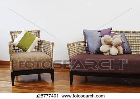 Stock Image - Couch and an armchair on a hardwood floor. Fotosearch