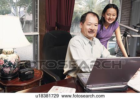 Father and his daughter looking at a laptop View Large Photo Image Stock Photo - Father and his daughter looking at a laptop. Fotosearch
