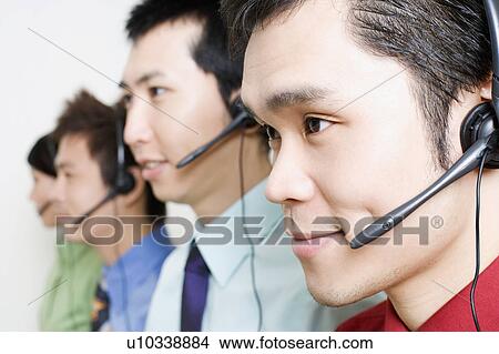Four customer service representatives talking on headsets View Large Photo Image Picture - Four customer service representatives talking on headsets. Fotosearch