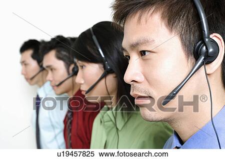 Stock Photography - Four customer service representatives talking on headsets. Fotosearch
