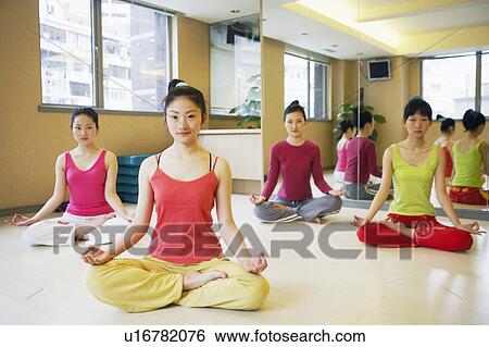 Stock Photograph - Four young women sitting in the lotus position. Fotosearch