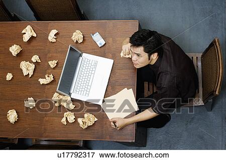 High angle view of a businessman holding a paper and thinking View Large Photo Image Stock Photo - High angle view of a businessman holding a paper and thinking. Fotosearch