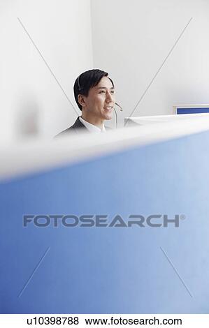 Stock Photo - High angle view of a customer service representative wearing a headset. Fotosearch