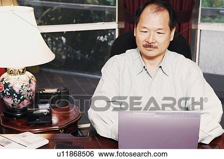 Stock Photograph - High angle view of a senior man using a laptop. Fotosearch