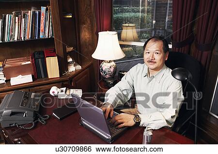 Stock Photograph - High angle view of a senior man using a laptop. Fotosearch