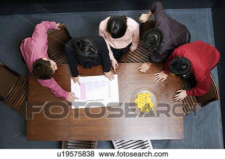 High angle view of two businesswomen and three businessmen discussing a bar graph View Large Photo Image Stock Photo - High angle view of two businesswomen and three businessmen discussing a bar graph. Fotosearch