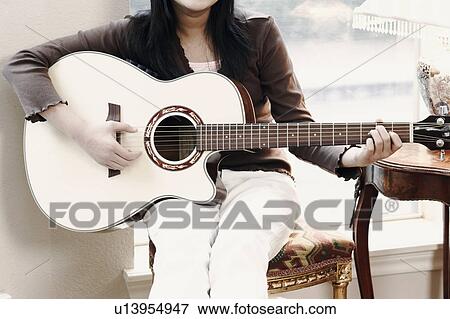 Mid section view of a girl playing the guitar View Large Photo Image Stock Photo - Mid section view of a girl playing the guitar. Fotosearch