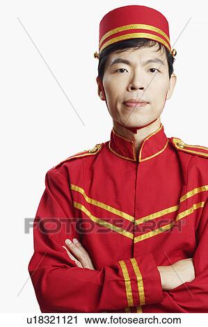 Stock Image - Portrait of a bellhop with his arms crossed. Fotosearch