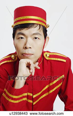 Portrait of a bellhop with his hand on his chin View Large Photo Image Stock Image - Portrait of a bellhop with his hand on his chin. Fotosearch