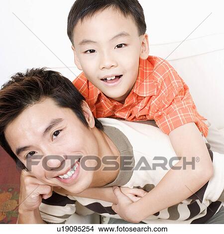 Picture - Portrait of a boy riding piggyback on his father. Fotosearch