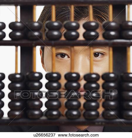 Stock Photo - Portrait of a businessman behind an abacus. Fotosearch
