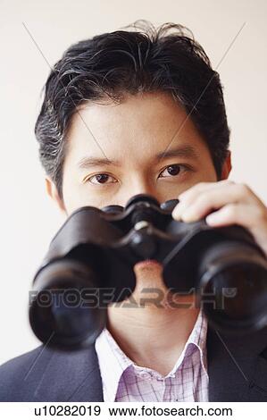 Portrait of a businessman holding a pair of binoculars View Large Photo Image Stock Photo - Portrait of a businessman holding a pair of binoculars. Fotosearch