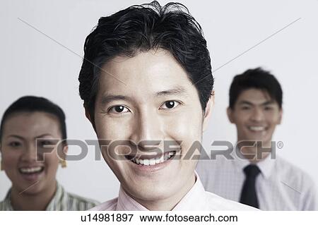 Portrait of a businessman smiling with his colleagues in the background View Large Photo Image Stock Photo - Portrait of a businessman smiling with his colleagues in the background. Fotosearch