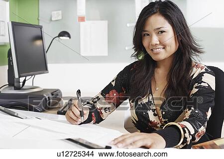 Portrait of a businesswoman writing with a pen View Large Photo Image Picture - Portrait of a businesswoman writing with a pen. Fotosearch