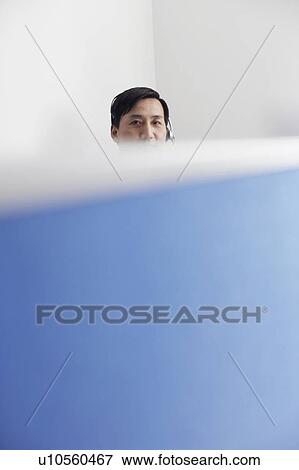 Portrait of a customer service representative behind a cubicle View Large Photo Image Stock Photo - Portrait of a customer service representative behind a cubicle. Fotosearch