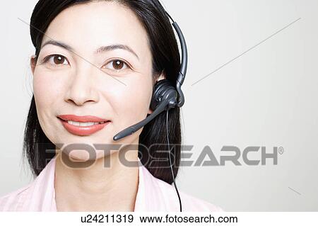 Stock Photo - Portrait of a female customer service representative using a headset. Fotosearch