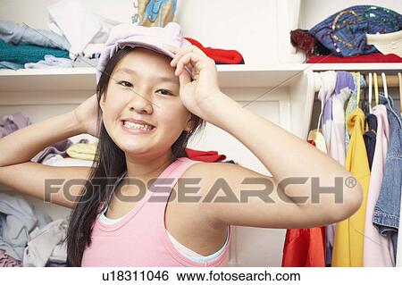Stock Photograph - Portrait of a girl holding a cap. Fotosearch