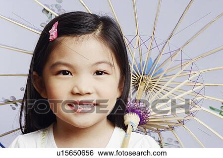 Stock Photograph - Portrait of a girl holding a parasol and smiling. Fotosearch