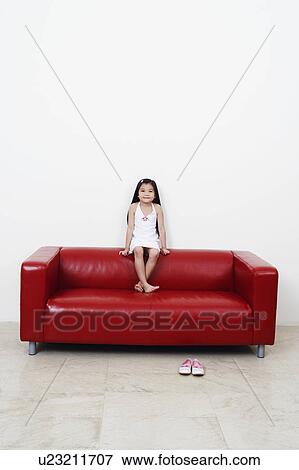 Stock Photo - Portrait of a girl sitting on a couch. Fotosearch