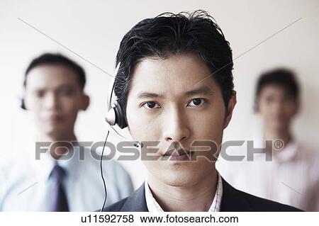 Stock Photo - Portrait of a male customer service representative with two colleagues. Fotosearch