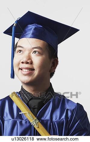 Stock Photo - Portrait of a male graduate holding a diploma. Fotosearch