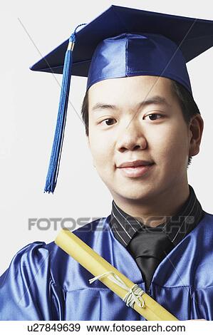 Stock Photo - Portrait of a male graduate holding a diploma. Fotosearch