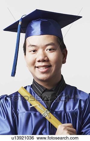 Stock Photograph - Portrait of a male graduate holding a diploma. Fotosearch