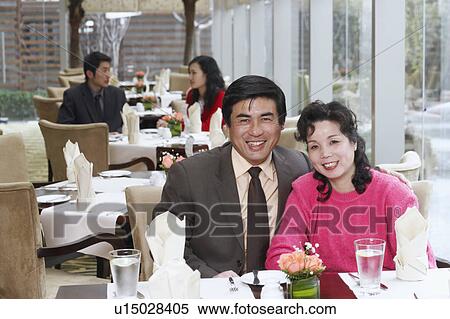 Stock Photography - Portrait of a mature couple sitting in a restaurant smiling. Fotosearch