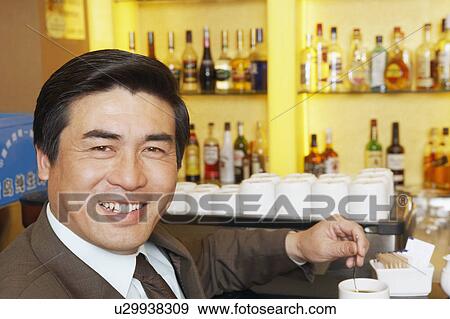 Portrait of a mature man stirring a cup of coffee View Large Photo Image Stock Photo - Portrait of a mature man stirring a cup of coffee. Fotosearch