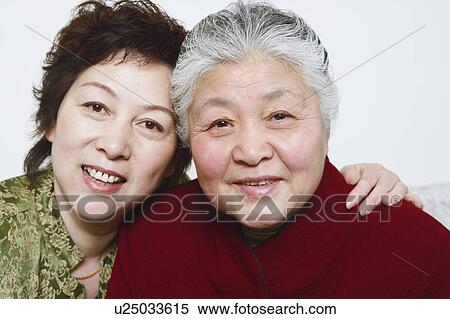 Stock Photography - Portrait of a mature woman and a senior woman smiling. Fotosearch