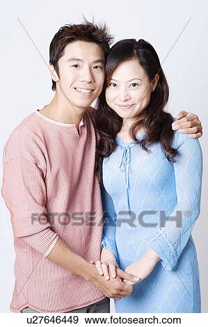Stock Photo - Portrait of a mid adult man and a young woman smiling. Fotosearch